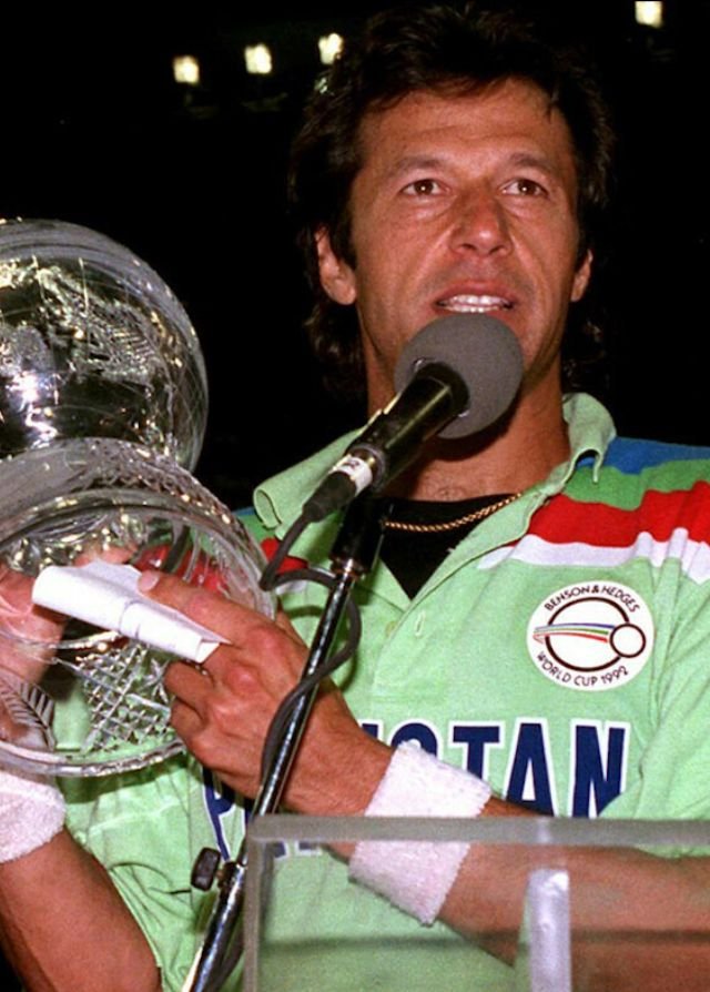 Imran Khan holding the microphone and speaking after winning the 1992 Cricket World Cup, wearing the iconic green Pakistan team kit with the Benson & Hedges logo.